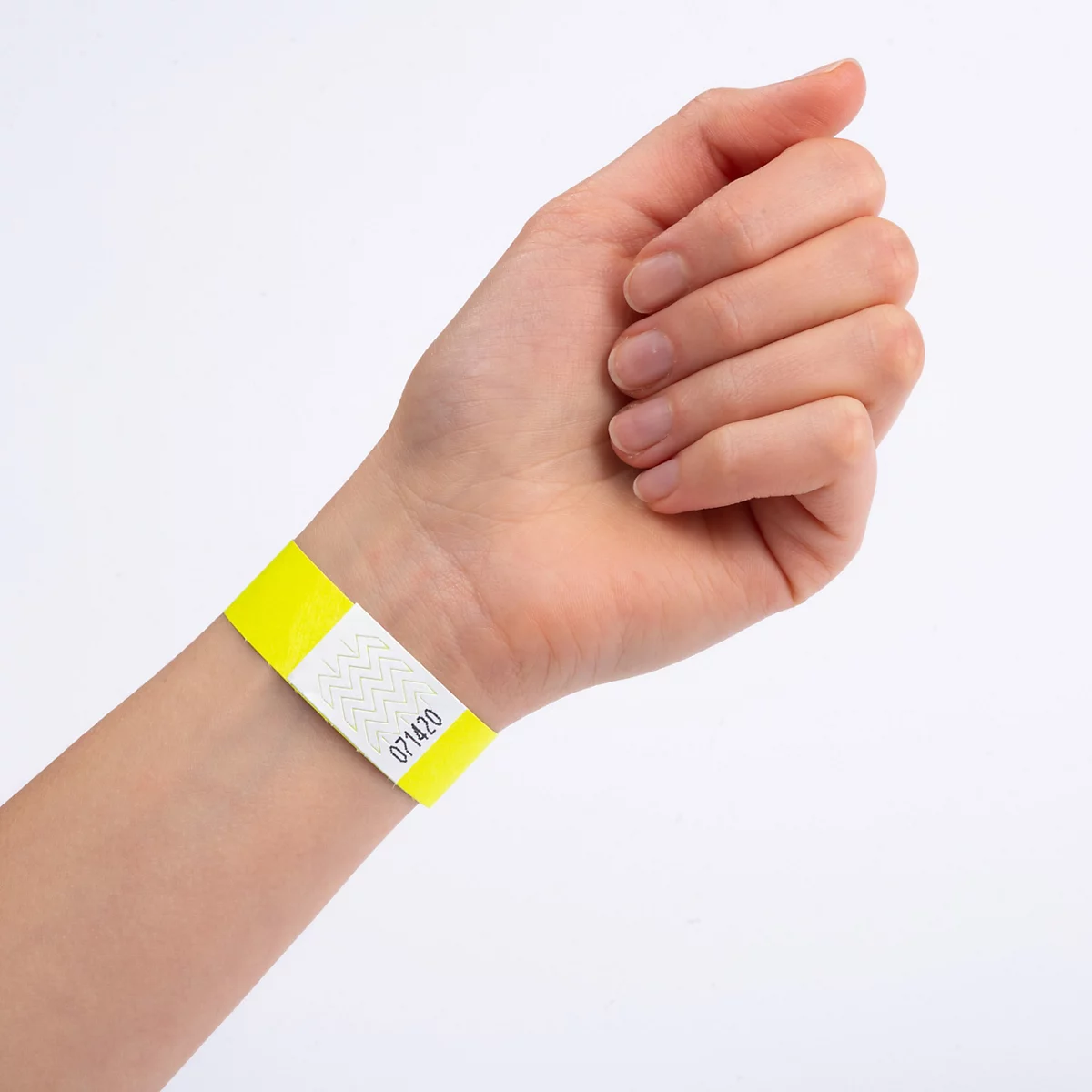 Gelbes Kontrollarmband mit weißem Feld und aufgedruckter Nummer an einem menschlichen Handgelenk.