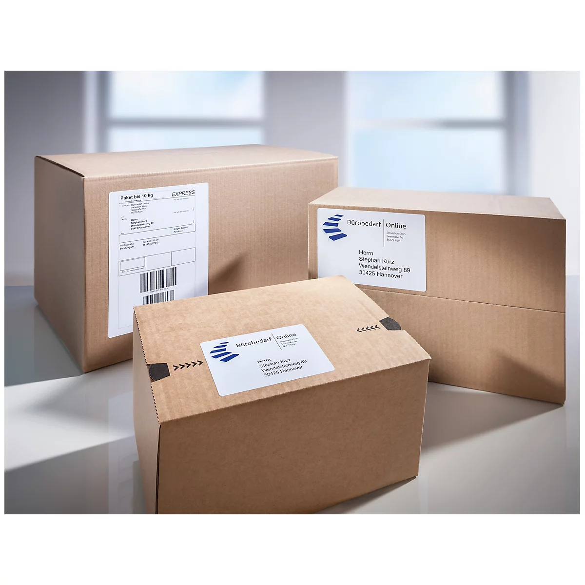 Drie bruine verzenddozen met etiketten. De voorste doos heeft een barcode-etiket.