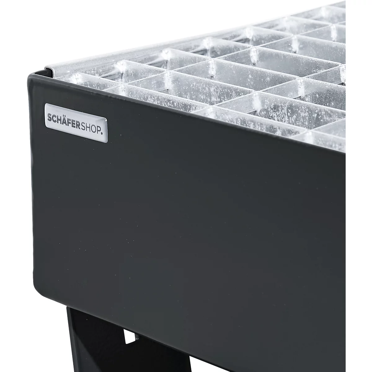 Récipient rectangulaire noir avec un insert transparent quadrillé. 'SCHÄFERSHOP' est sur le métal.