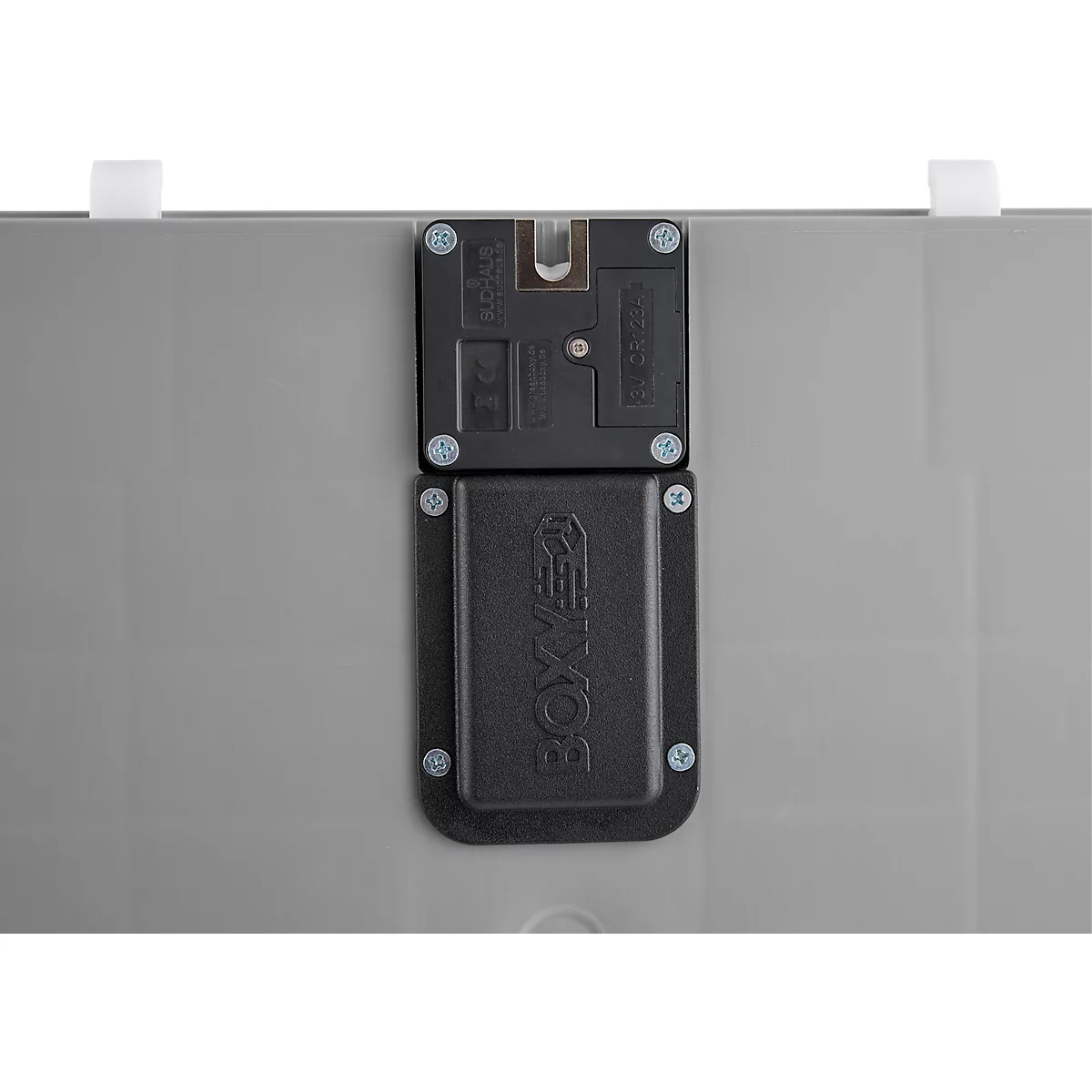 Gros plan d'une serrure noire avec l'inscription "BOXXER" sur fond gris. La serrure est fixée avec des vis.