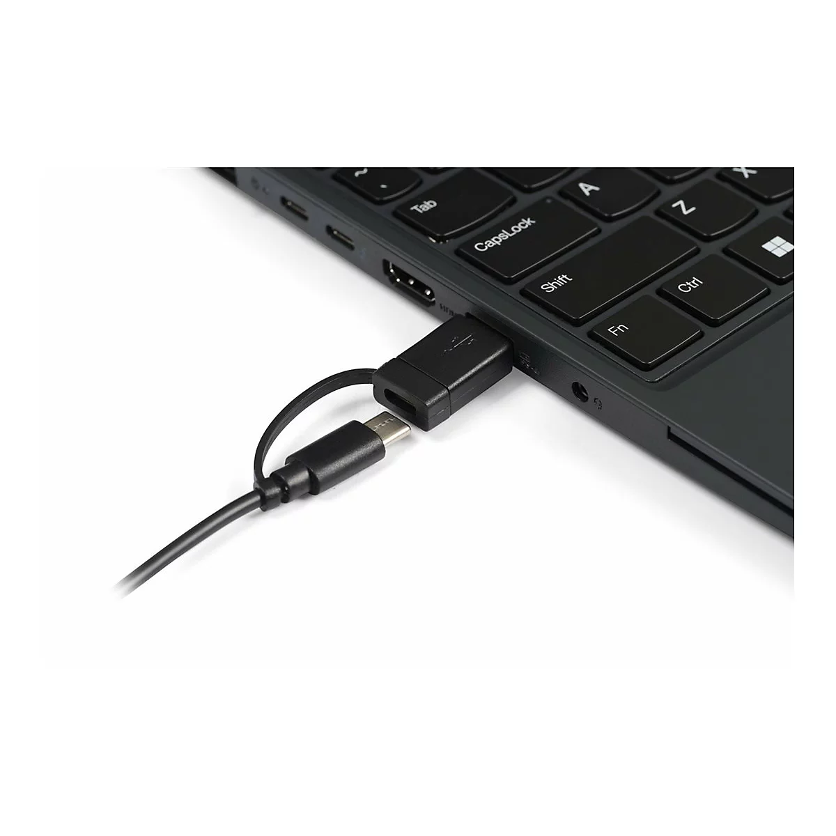 Ein USB-Adapter steckt im Laptop, ein zweiter Stecker hängt an einem kurzen Kabel daneben.