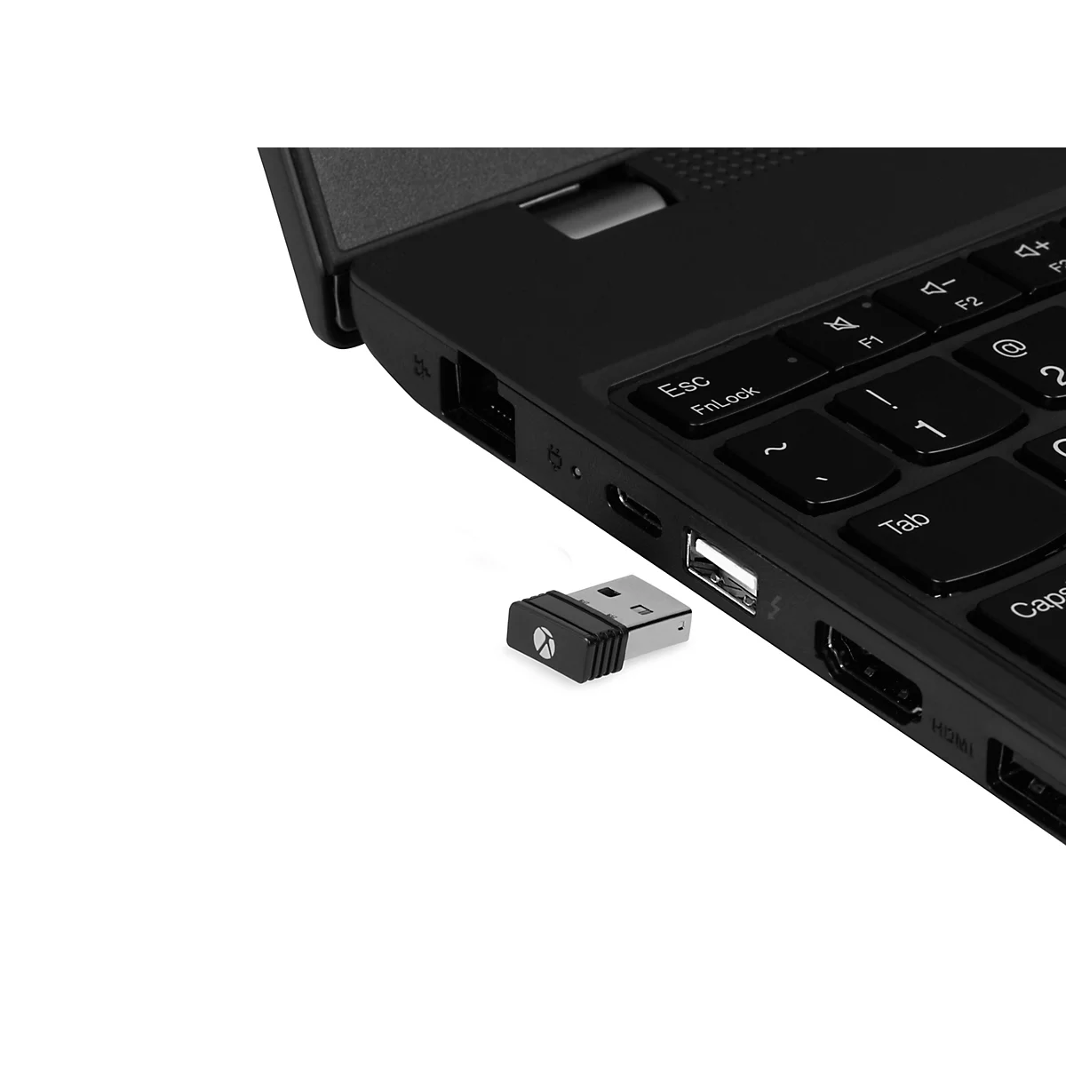 Schwarzer USB-Empfänger neben einem schwarzen Laptop. Der USB-Stecker ist in der Nähe des USB-Anschlusses platziert.