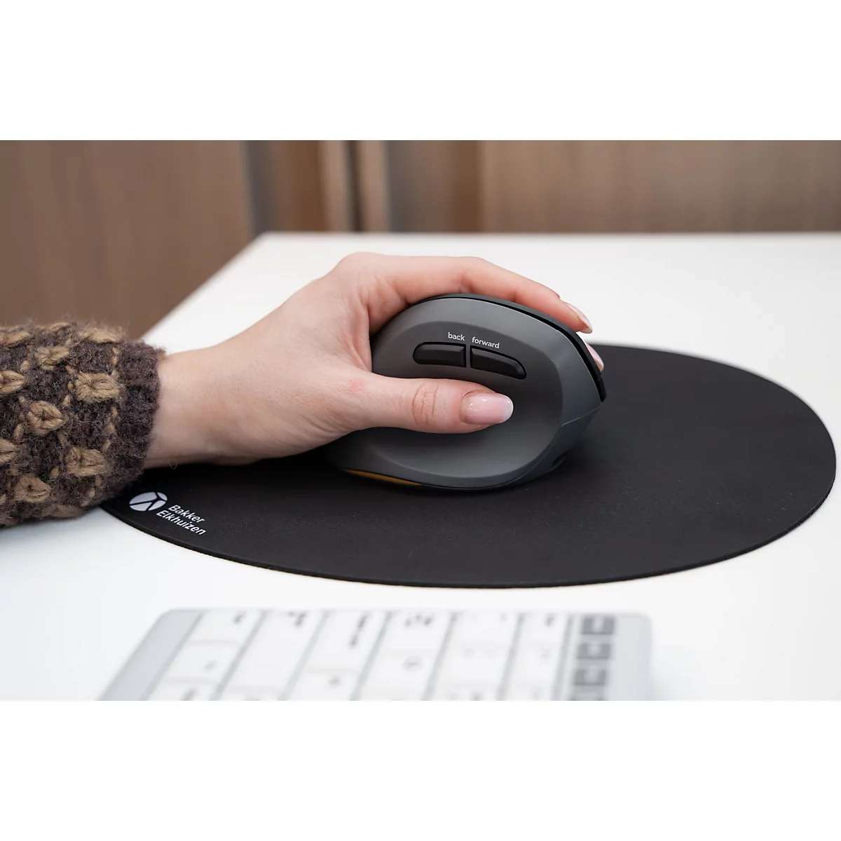 Hand bedient eine graue, ergonomische Vertikalmaus auf einem schwarzen Mauspad.
