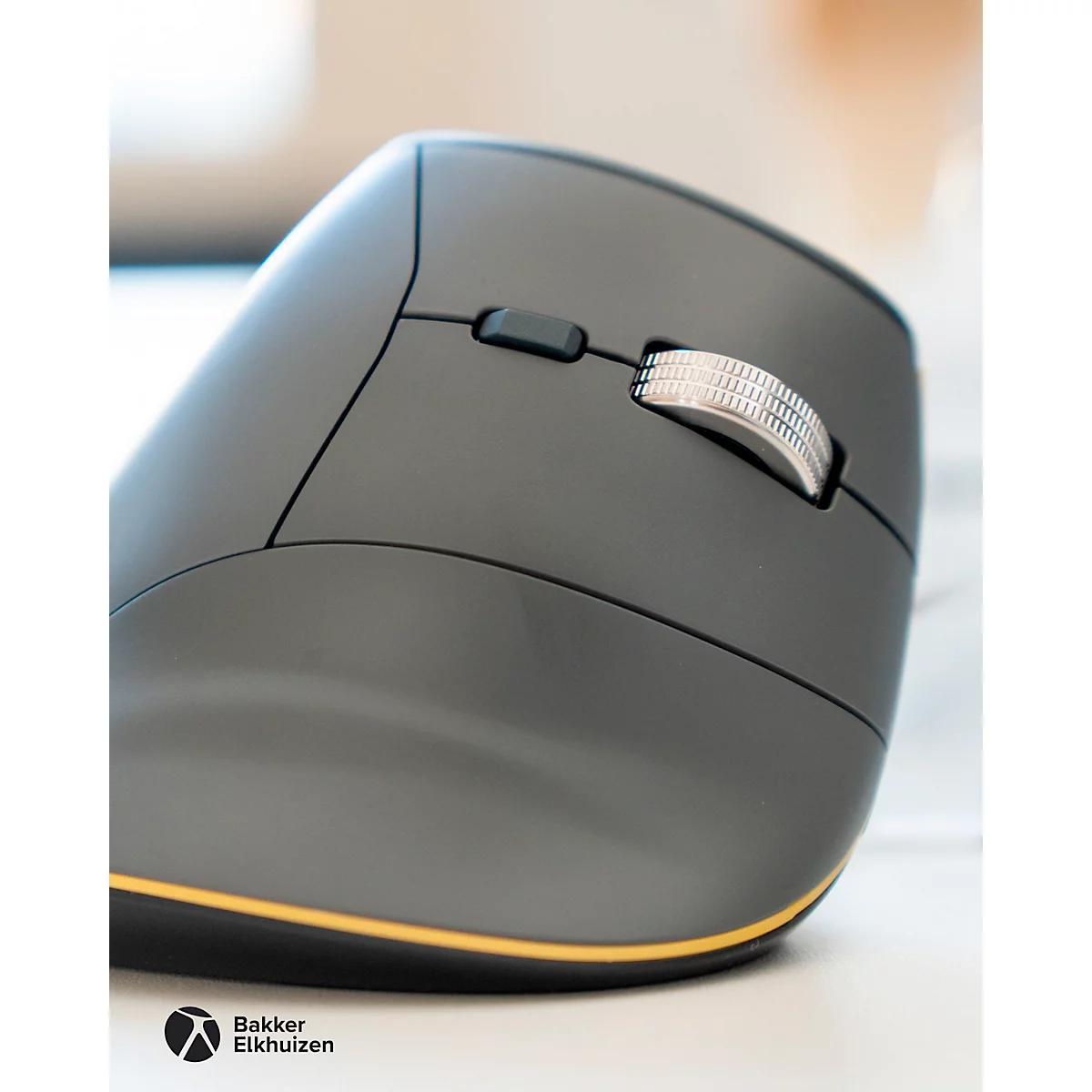 Drahtlose, ergonomische Maus in Dunkelgrau mit gelbem Rand. Sichtbar sind Rollrad, Seitentasten und Firmenlogo.