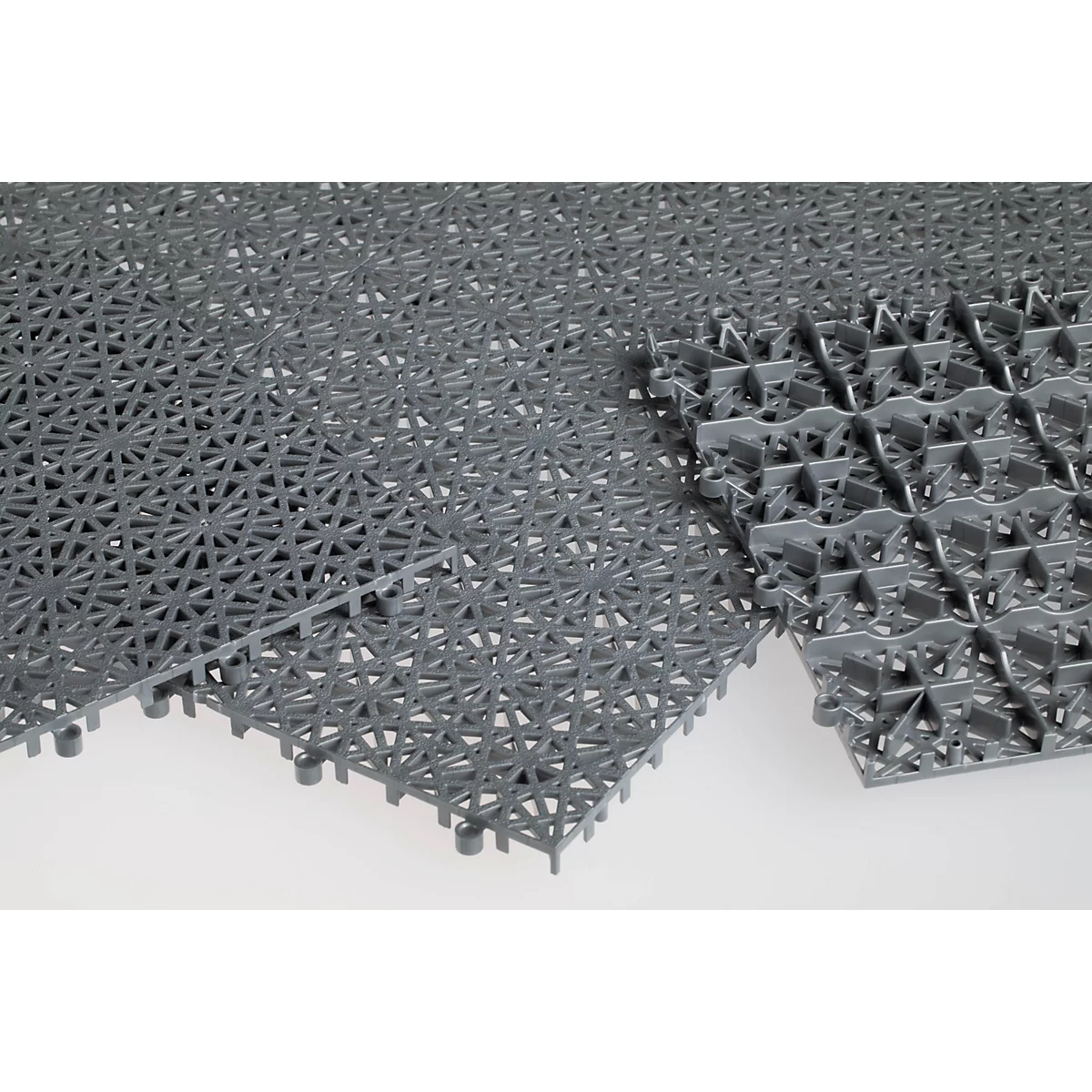Baldosa de suelo de plástico gris con un patrón de rejilla en forma de estrella sobre fondo claro.