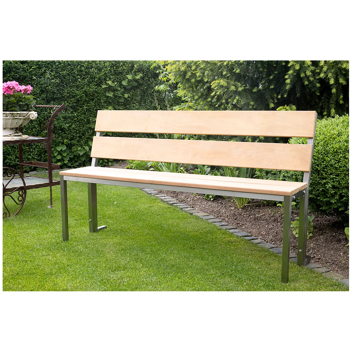 Banc de jardin en bois avec dossier, posé sur une pelouse verte devant une haie.