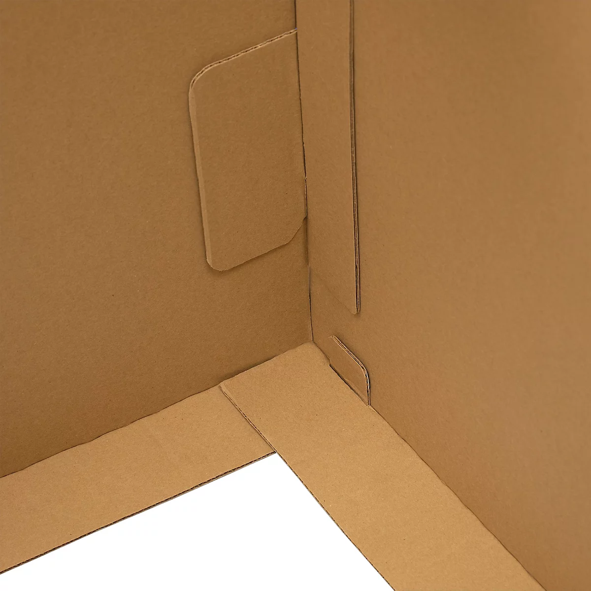 Gros plan sur un coin en carton brun. Découpes pour assembler les pièces.