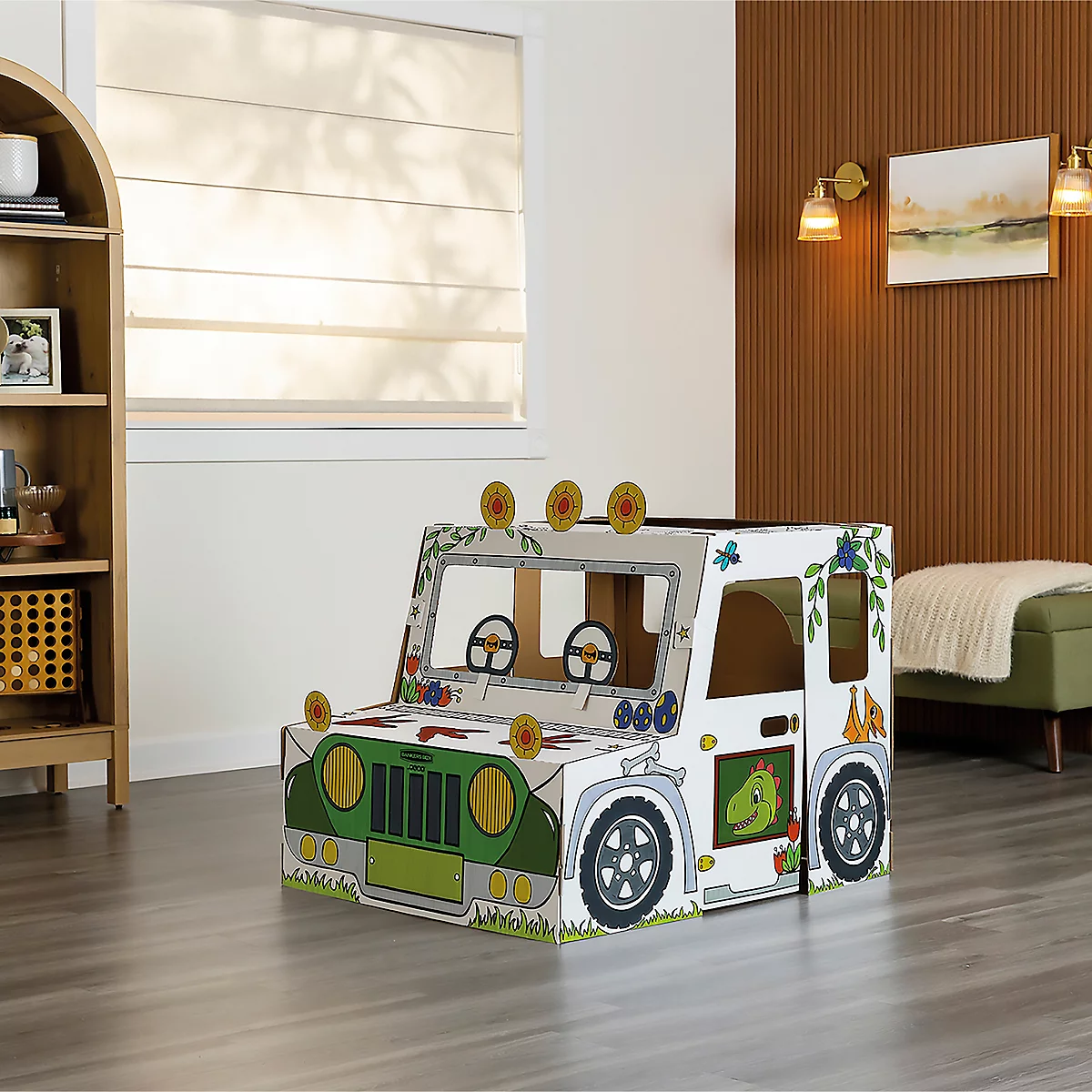 Une voiture jouet en carton décorée de détails verts, de motifs de dinosaures et de fleurs, debout dans une pièce.