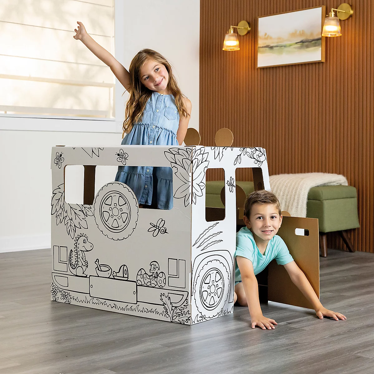 Twee kinderen spelen in een geschilderd speelhuis in de vorm van een auto. Meisje zwaait, jongen kruipt uit de deur. Achtergrond: kamer.