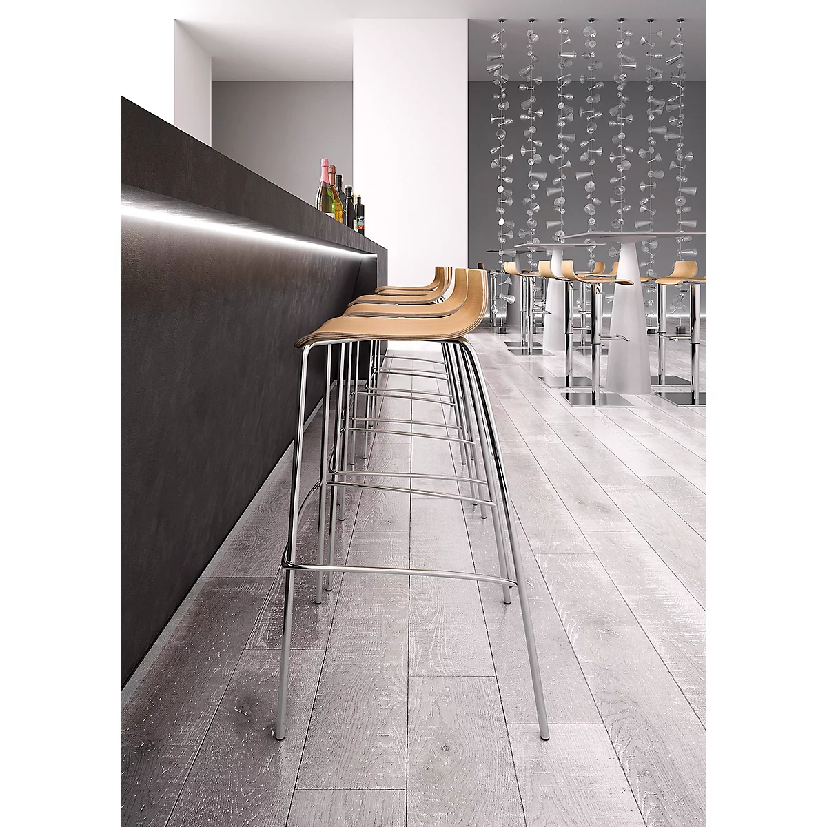 Row of bar stools in front of a bar; light wooden seats, metal legs, dark bar top, light wall.