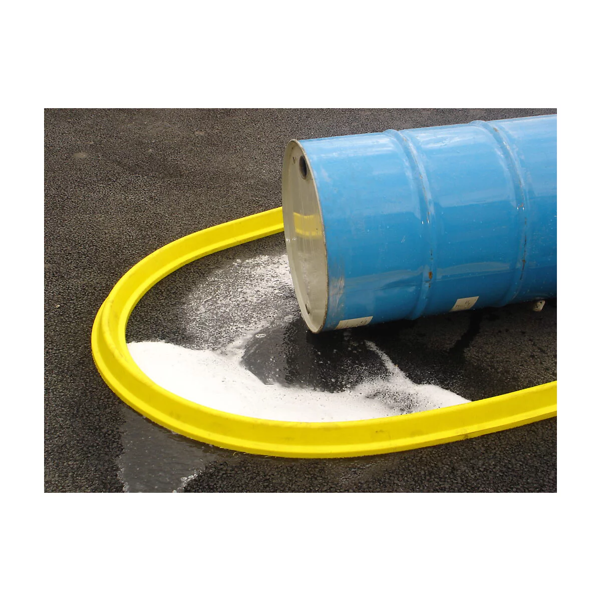 Blue barrel lying with white powder, yellow safety barrier, gray asphalt.