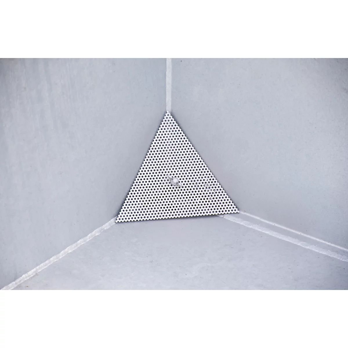 Pièce métallique triangulaire perforée dans le coin. Deux petits trous. Fond gris avec des lignes blanches.