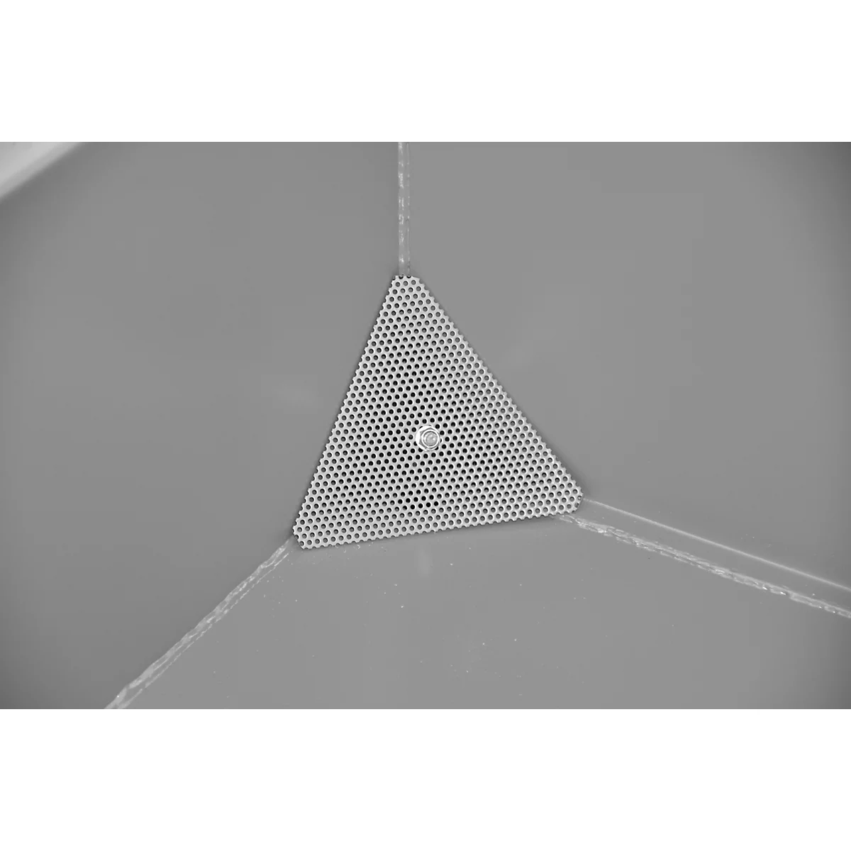 Gros plan en niveaux de gris d'une pièce métallique triangulaire et perforée, intégrée dans une tonalité grise. Au milieu, on voit un petit boulon argenté.