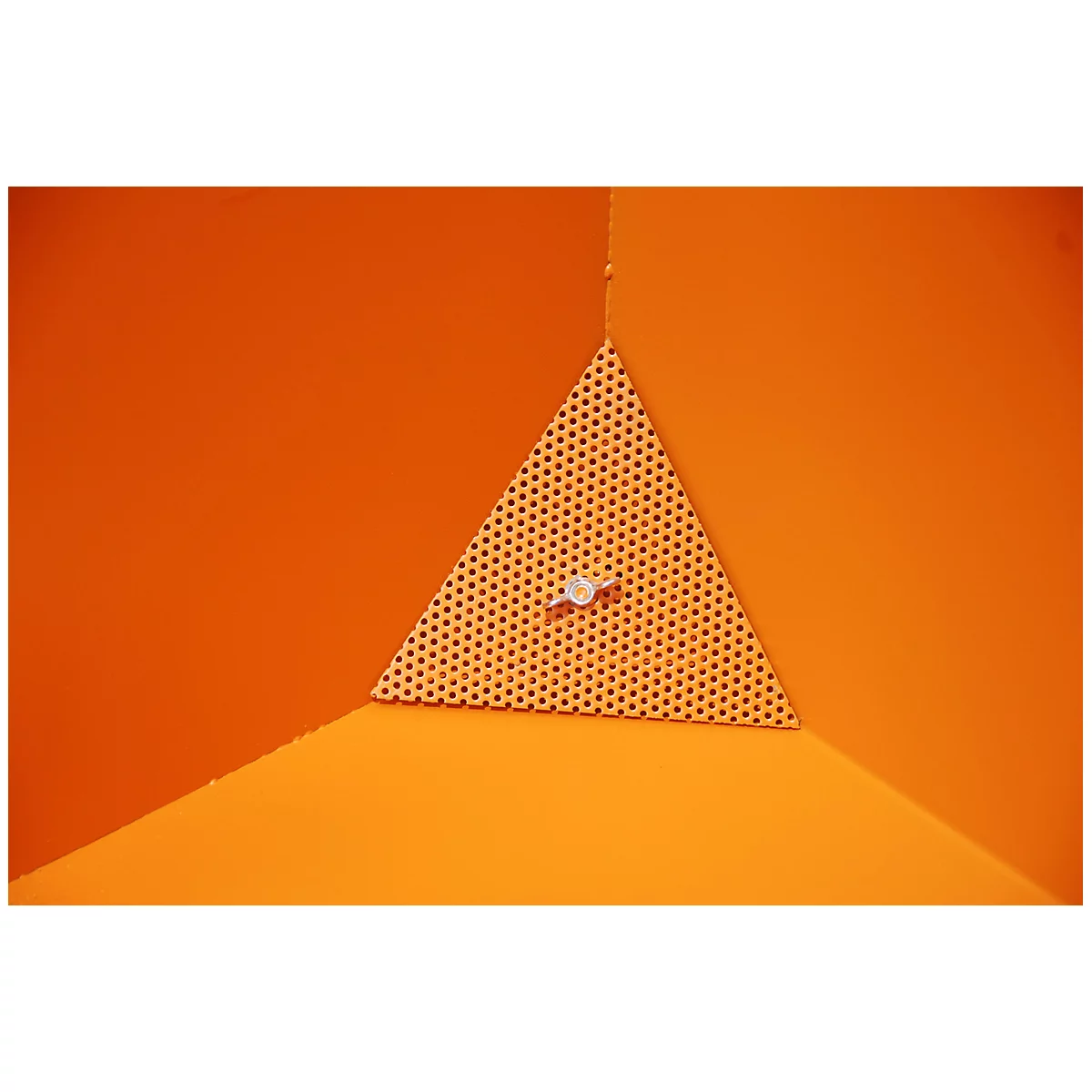 Ein orangefarbener Eckbereich mit einem perforierten dreieckigen Element, das an einer Wand befestigt ist, durch das ein kleiner Knopf verläuft.