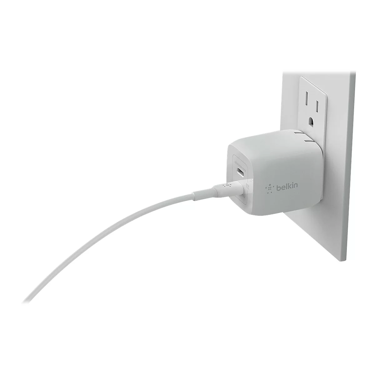 Chargeur Belkin blanc branché dans une prise murale, avec un câble blanc.