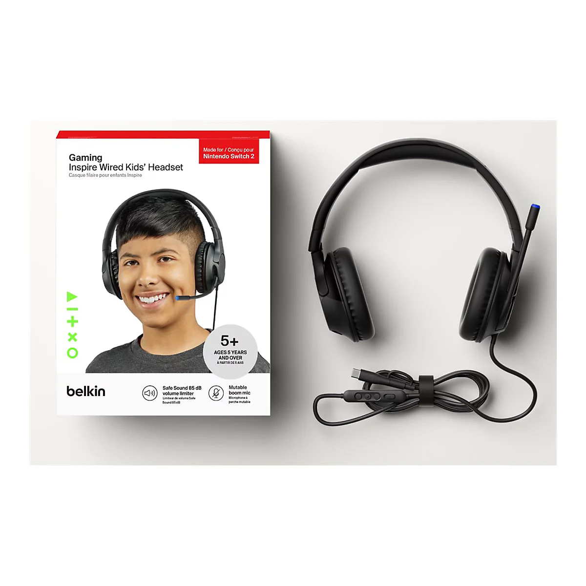 Ein Junge lächelt und trägt ein schwarzes Gaming-Headset, das auf der Verpackung abgebildet ist. Auf der Verpackung stehen Angaben zu Alter, Marke und Funktionen.