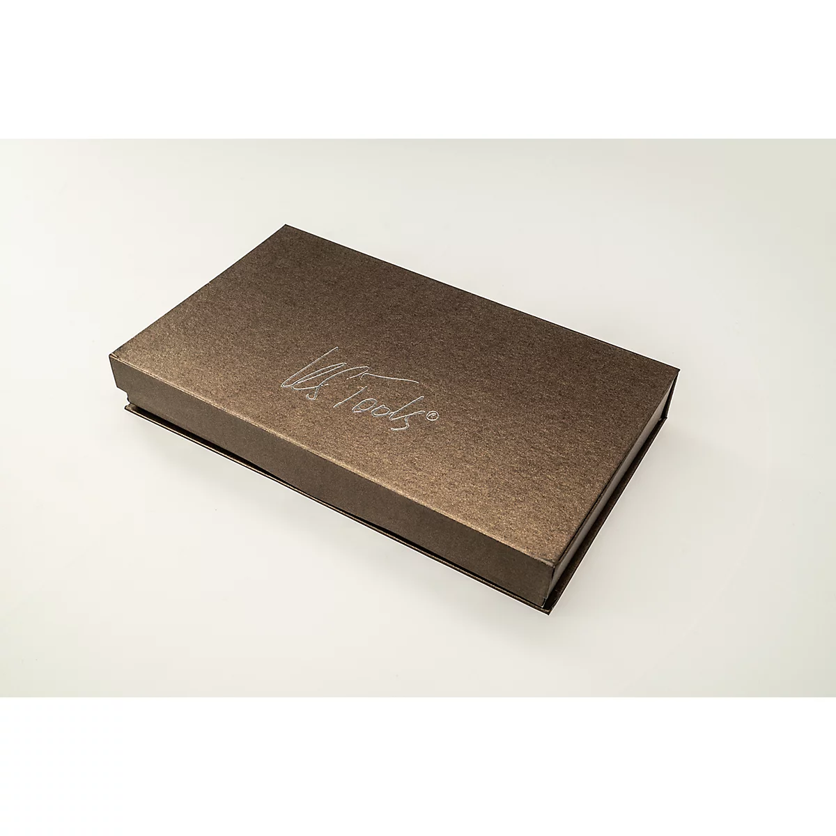 Braune Schachtel mit Schriftzug "vs. tools" liegt auf weißem Grund.