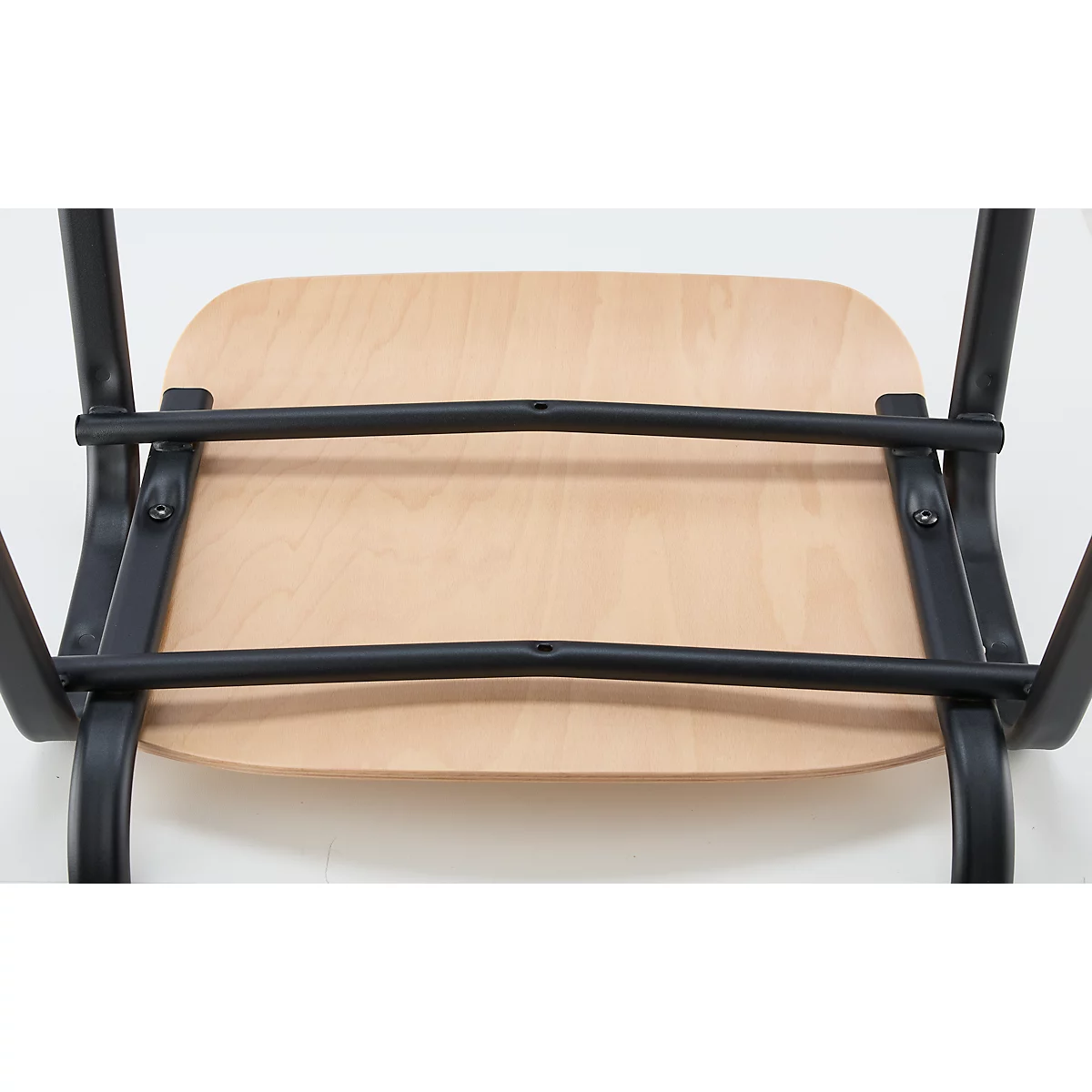Von unten fotografierter Stuhl. Holz Sitzfläche und schwarze Metallstreben.