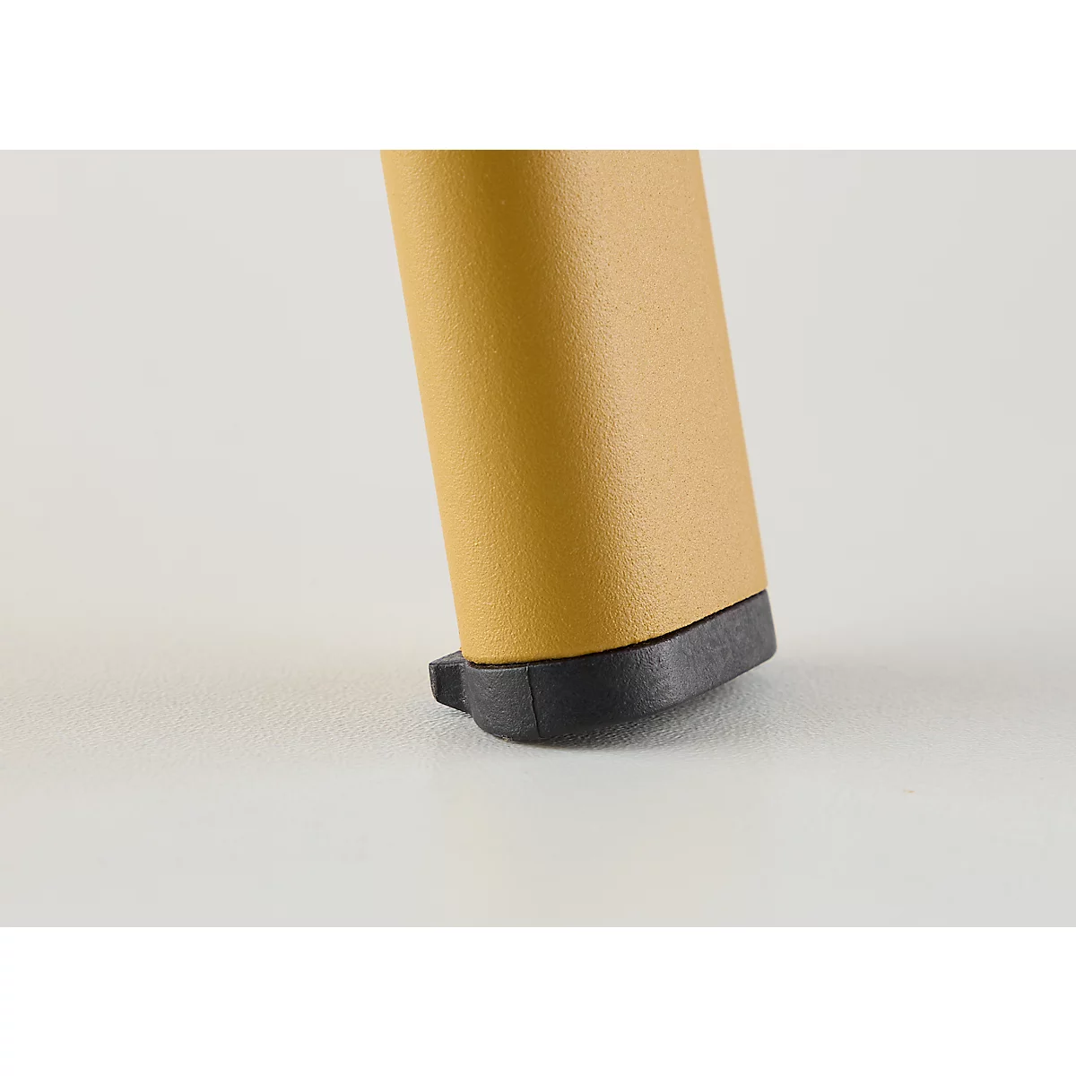 Detailopname van een beige schoenhiel met een zwarte zool en een smalle punt.