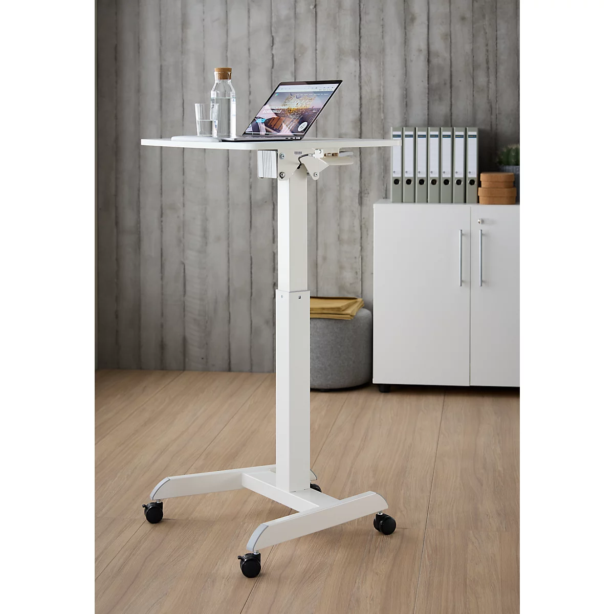 Witte staande tafel met laptop, glas en fles. Op de achtergrond een kastwand, houtlook.