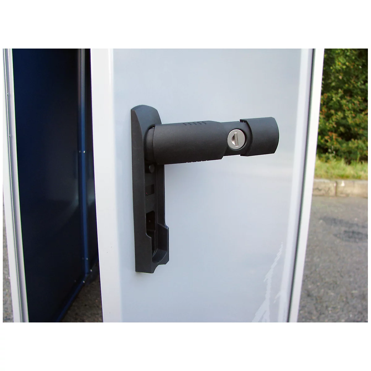 Black door handle with cylinder lock on a white door, a blue open cabinet in the background.