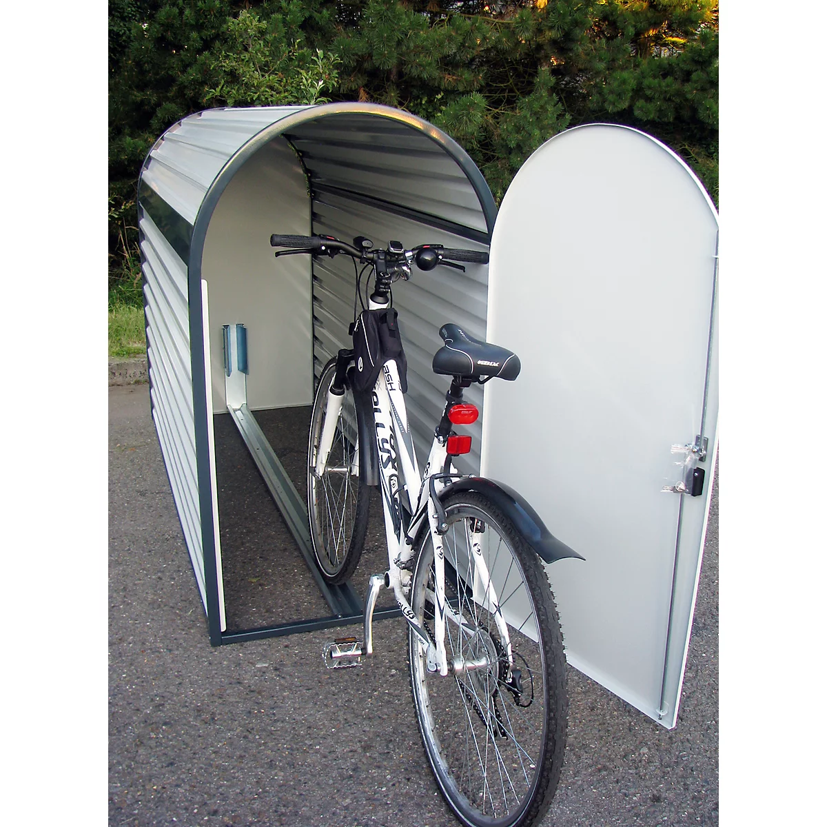Bicycle parked in a white and gray bicycle garage with the door open.