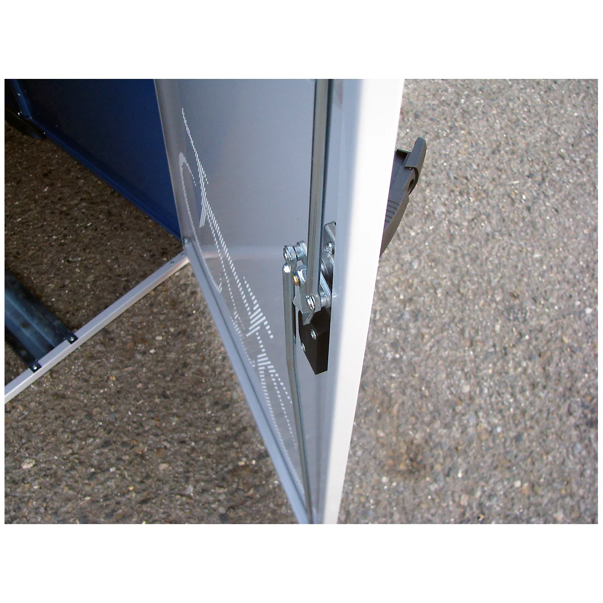 Close-up of a white door with metal hinge, behind it blue elements.