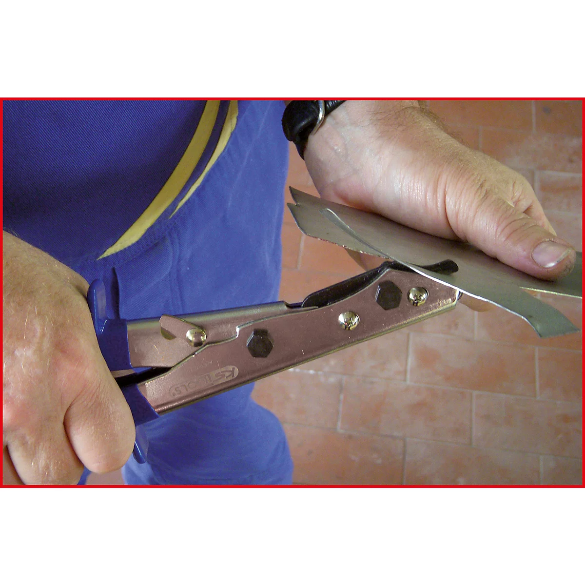 Person schneidet Blech mit einer Blechschere, Nahaufnahme.