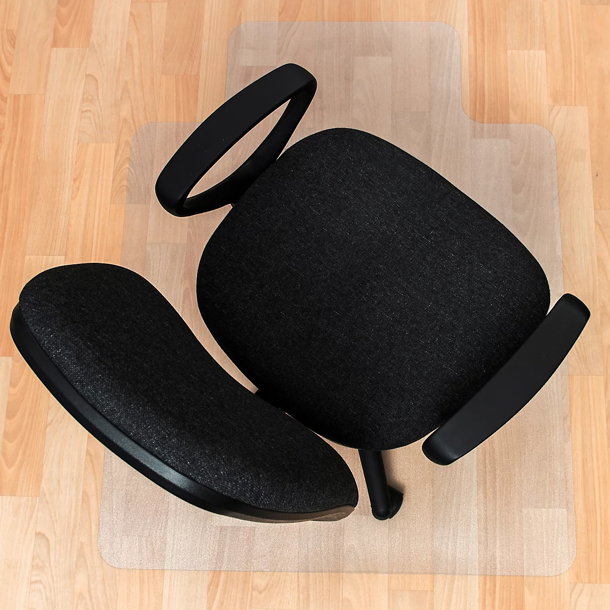 Zerlegter Bürostuhl, schwarze Sitzfläche und Armlehnen, auf hellem Holzboden.