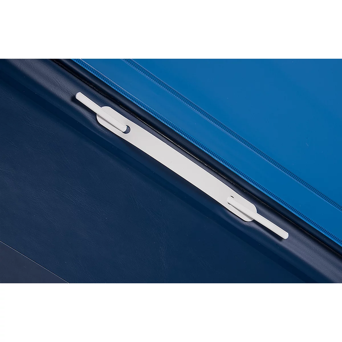 Close-up of a blue binder with a white clasp. The clasp extends diagonally across the image.