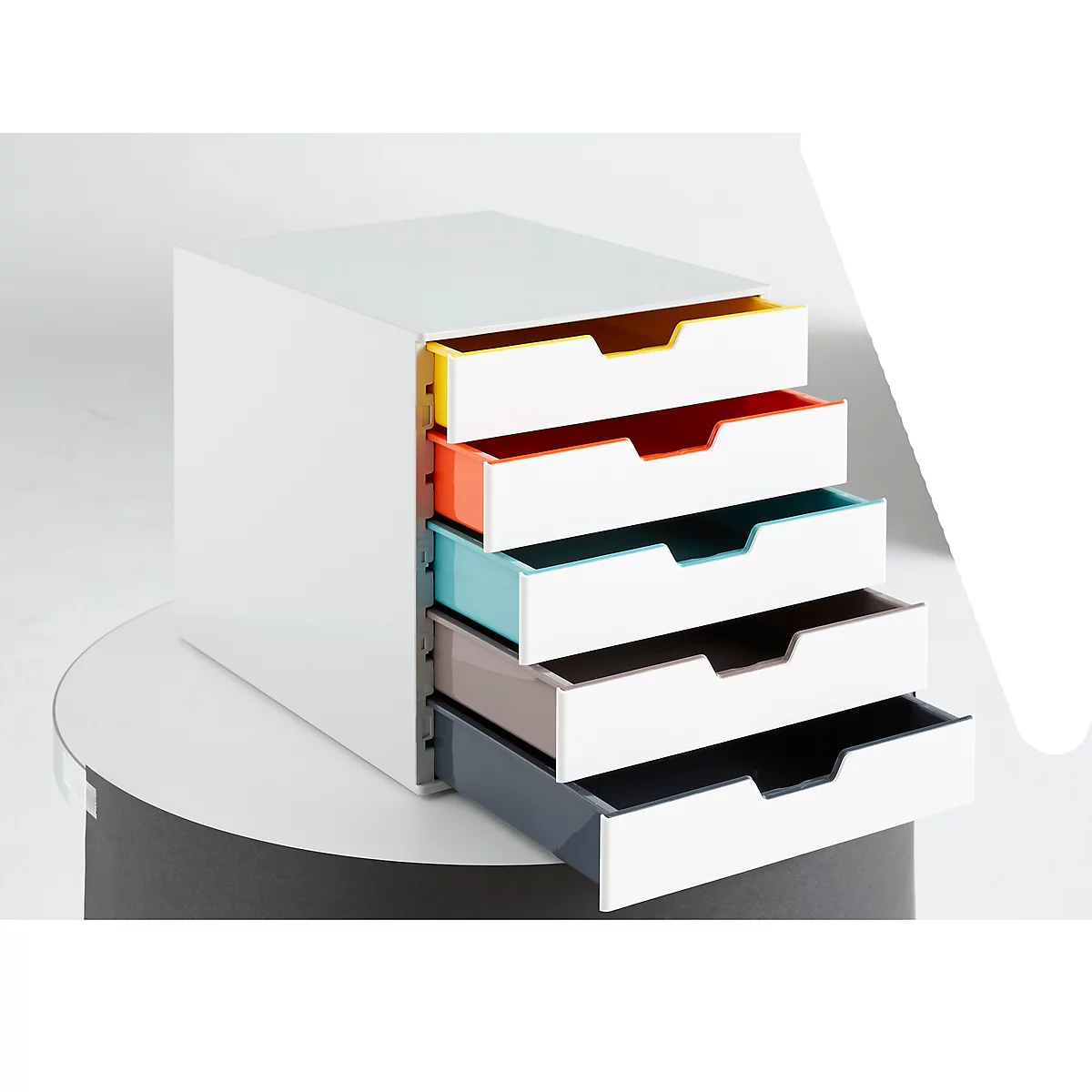 Système de tiroirs blanc avec cinq tiroirs de couleurs différentes. Jaune, rouge, turquoise, marron et bleu foncé.