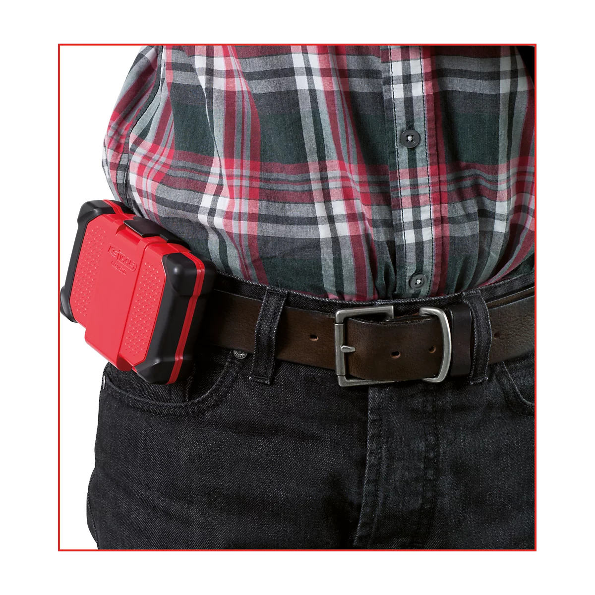 Personne portant une boîte à outils rouge à la ceinture, portant une chemise à carreaux et un jean. La boîte à outils est bordée de noir.