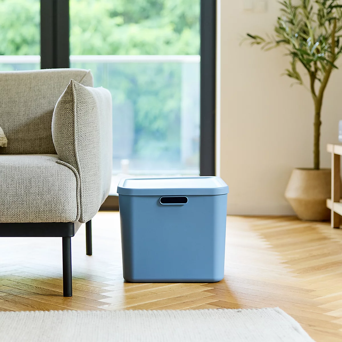 Boîte de rangement bleue avec couvercle et ouvertures pour poignées.