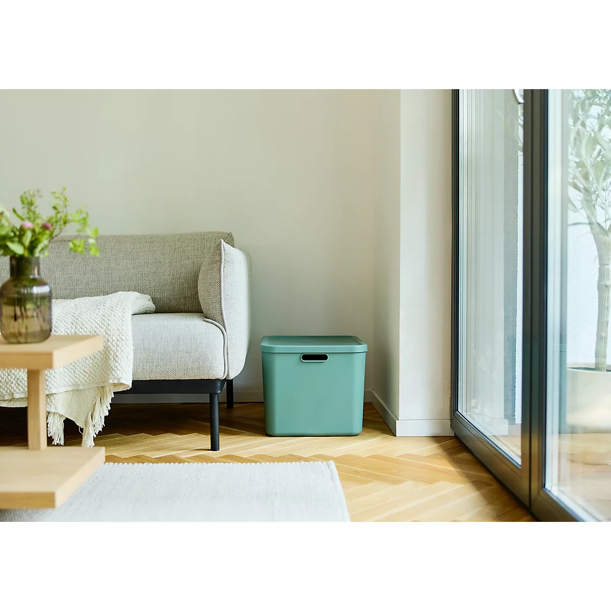 Boîte de rangement vert clair avec couvercle et encoche de poignée sur fond blanc.