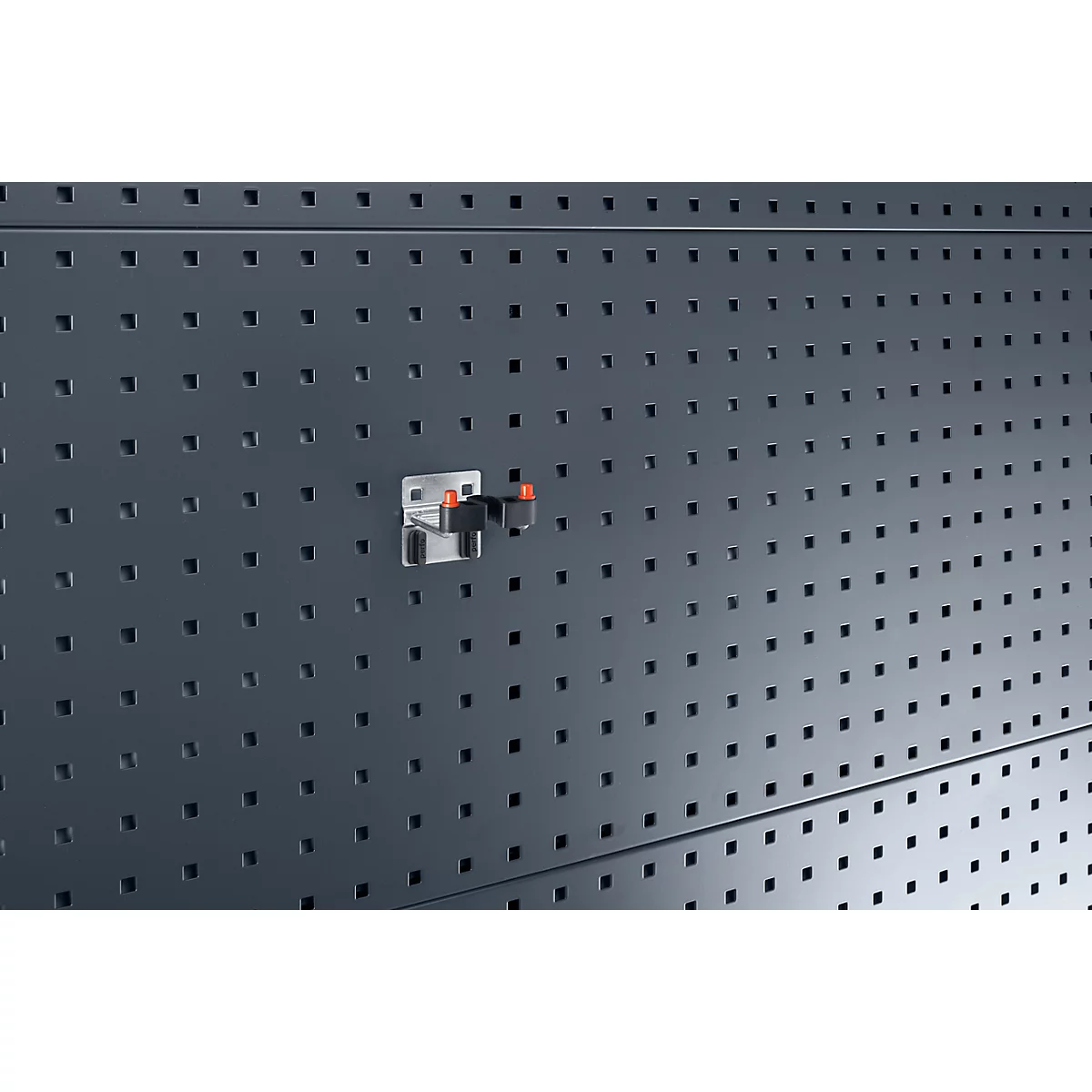 Detailaufnahme einer Halterung mit zwei roten Enden, befestigt an einer Lochwand.