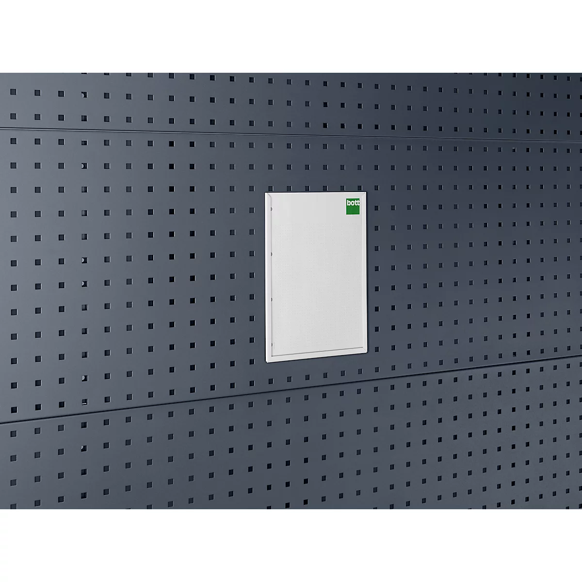 Weiße Tür in dunkler Wand mit Löchern. Oben rechts ein grüner Aufkleber.