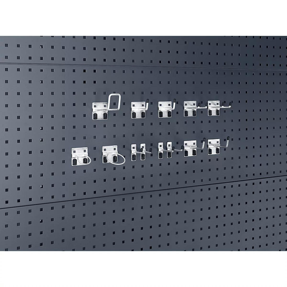 Graue Lochwand mit verschiedenen weißen Haken, die in die Löcher eingehängt sind.