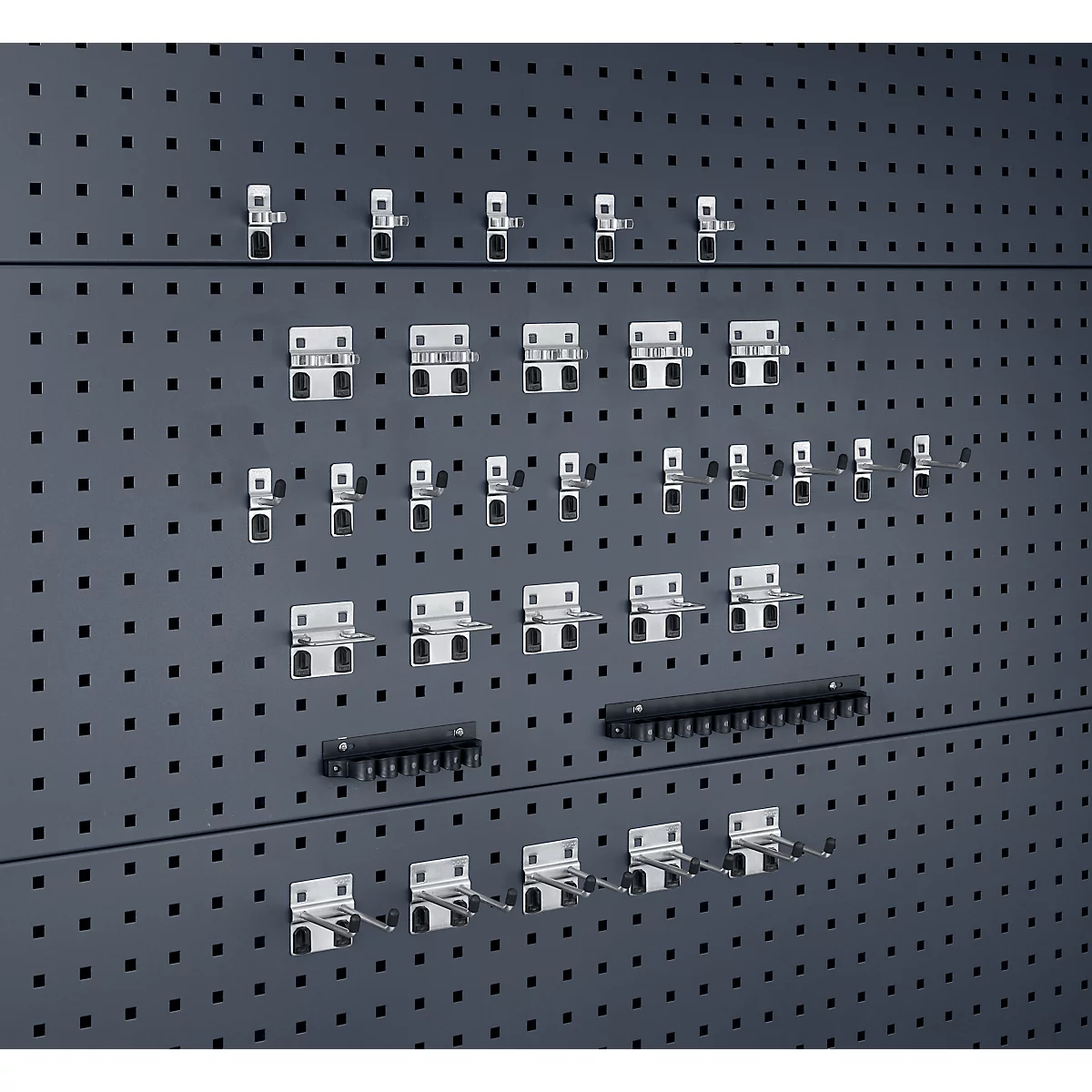 Grijze pegboard met diverse gereedschapshouders.