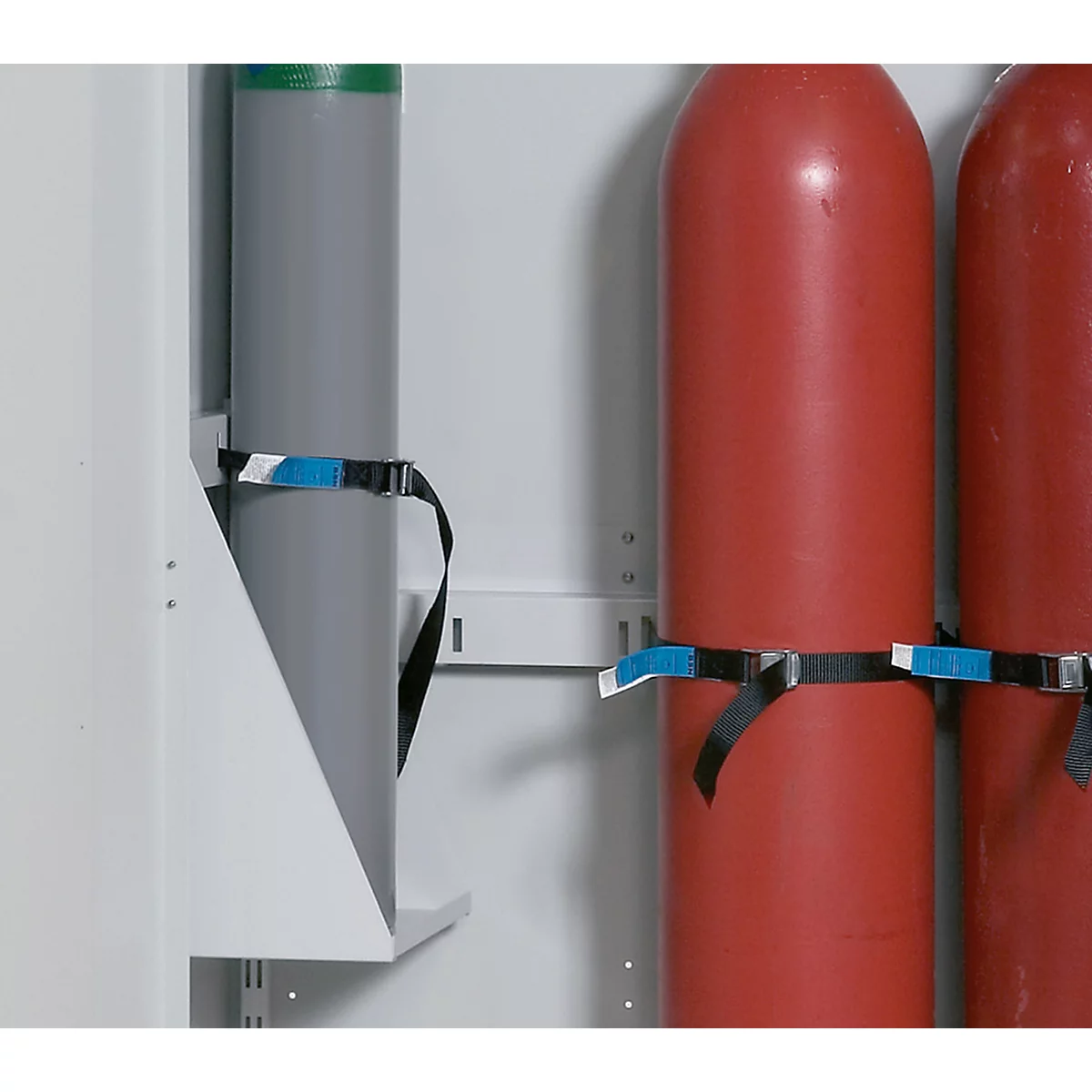 Gas cylinders in a cabinet, secured with straps.