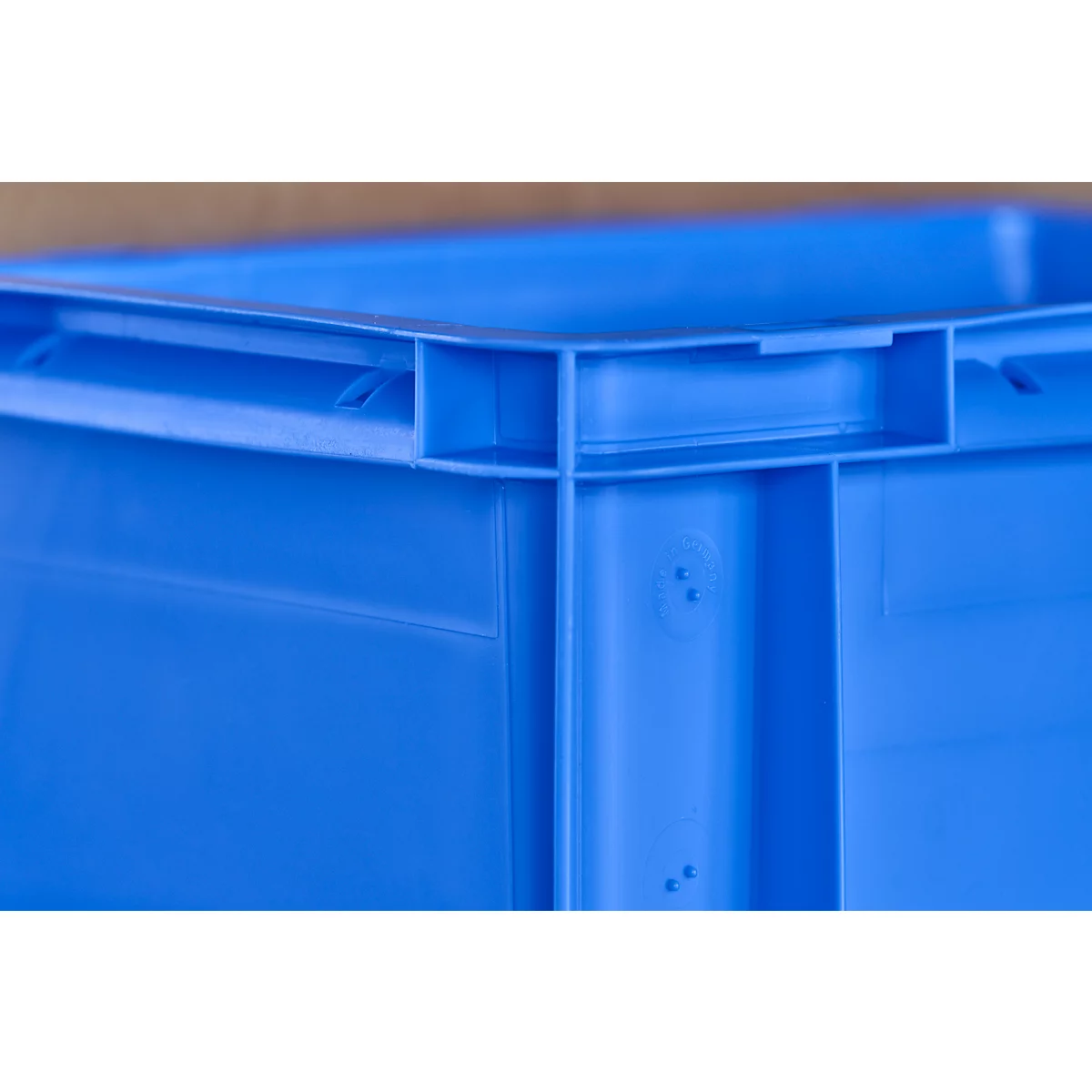 Corner of a blue plastic box, detail shot with visible connections and recesses.
