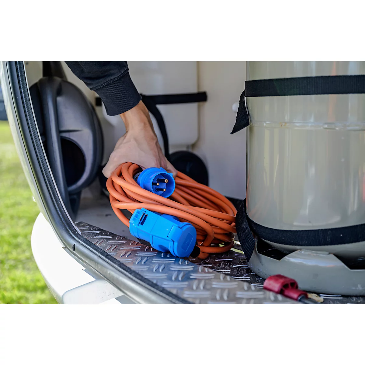 Caravane blanche avec deux fenêtres et une roue dans un cercle rouge.