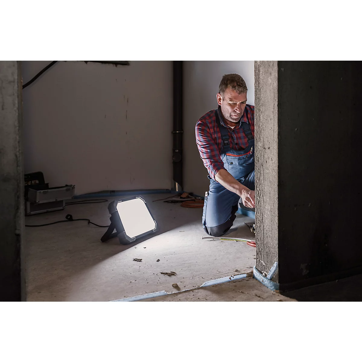 Zwarte LED-werklamp met grijze handgreep en scharnier verstelbaar in verschillende hoeken.
