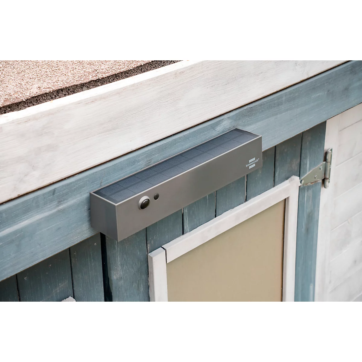 Ouvre-porte rectangulaire gris sur une porte en bois bleue, avec des boutons et une fenêtre.