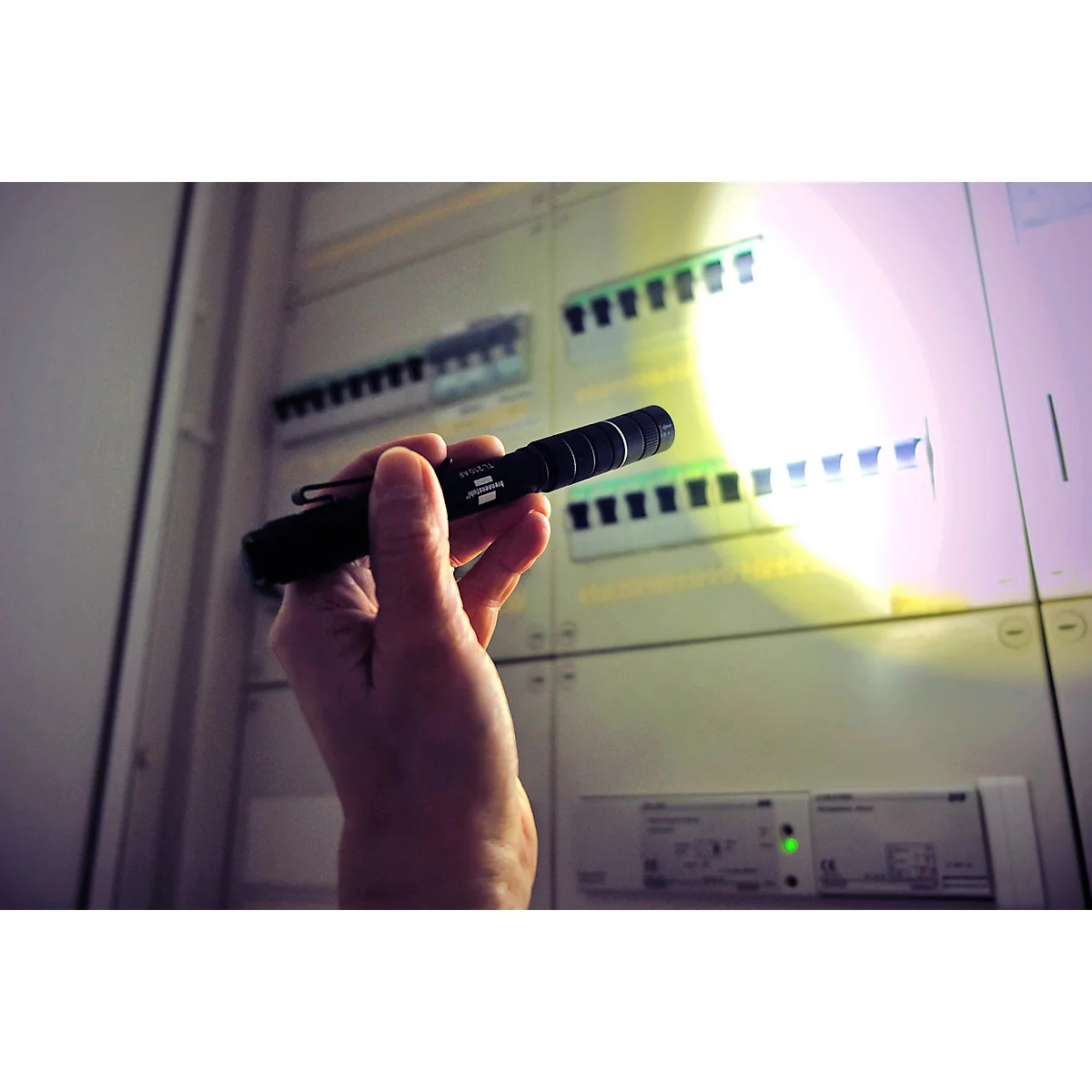 Eine schwarze Taschenlampe mit Clip, Detailaufnahme. Aufschrift: brennenstuhl TL 210 AF.