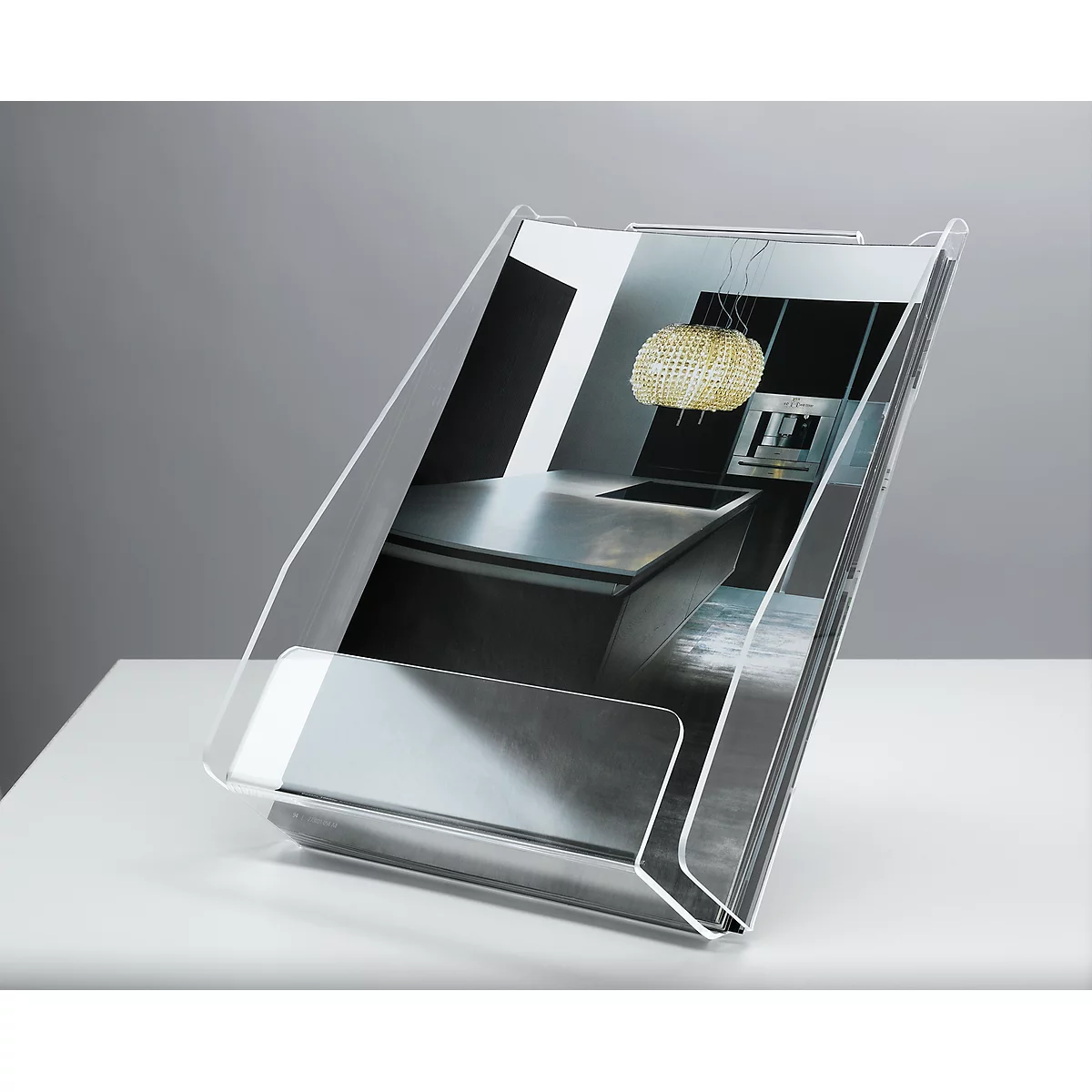 Transparent brochure holder with a picture of a kitchen, standing on a white table.