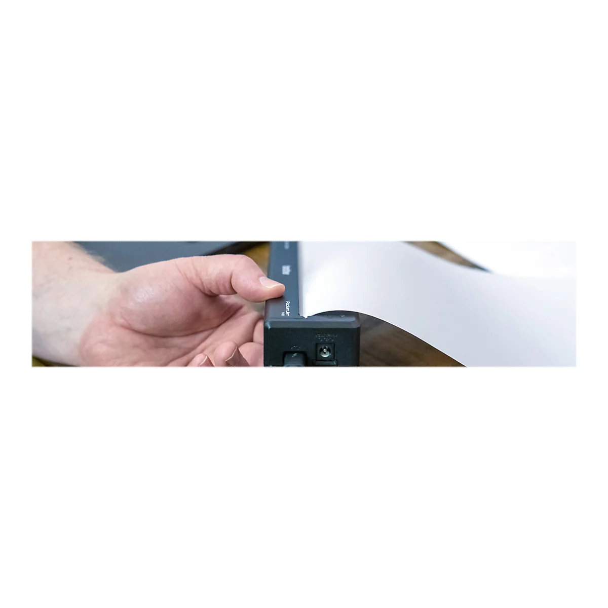 Hand hÃ¤lt einen SchwarzweiÃŸdruck, Papier wird aus einem Drucker gezogen.