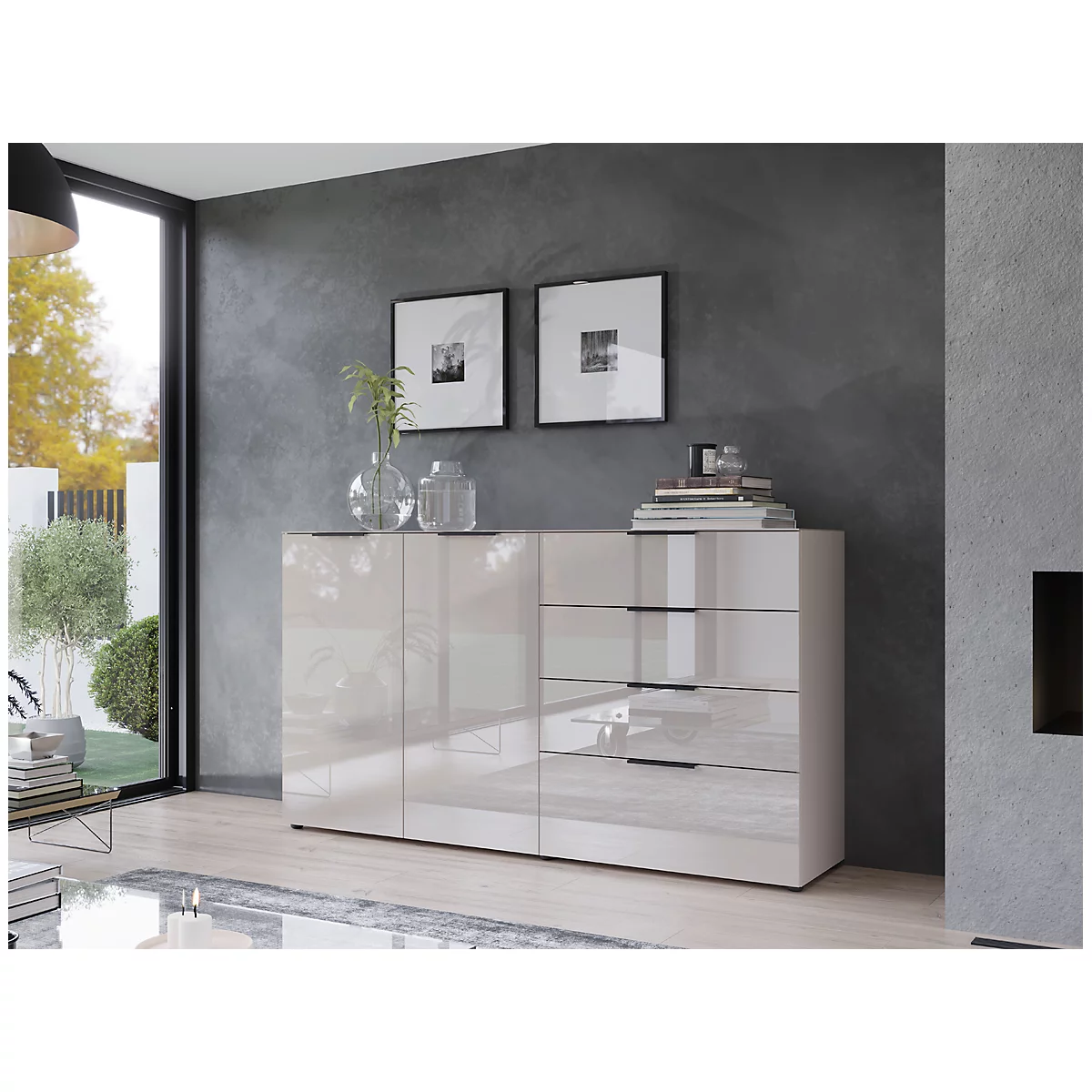 Buffet moderne de couleur crème contre un mur gris. Deux tableaux encadrés, des vases, des livres et une lampe sont également visibles.