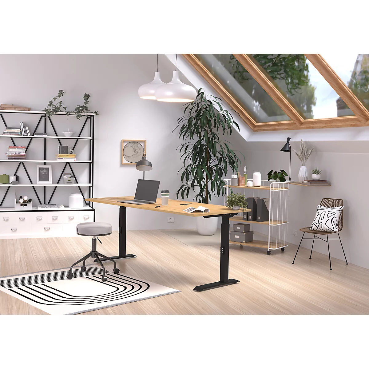 Un bureau à domicile lumineux avec un bureau réglable en hauteur, un ordinateur portable, une bibliothèque et un puits de lumière avec lumière naturelle.