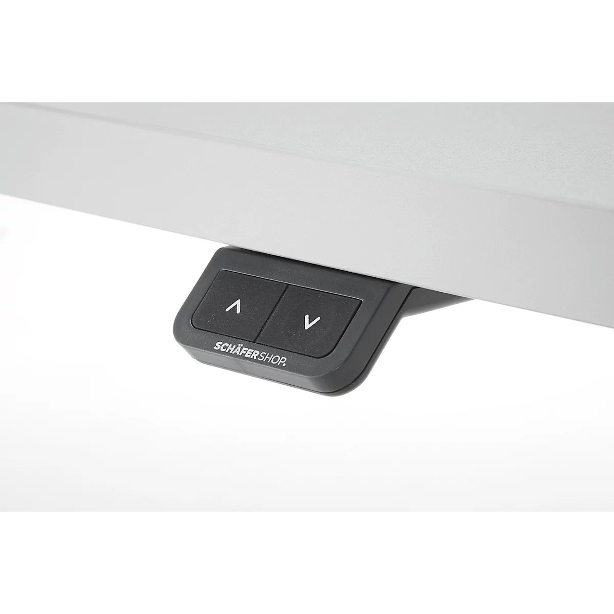 Gros plan sur les commandes d'un bureau réglable en hauteur électriquement. Boutons noirs avec des flèches et 'Schäfer Shor' en dessous.