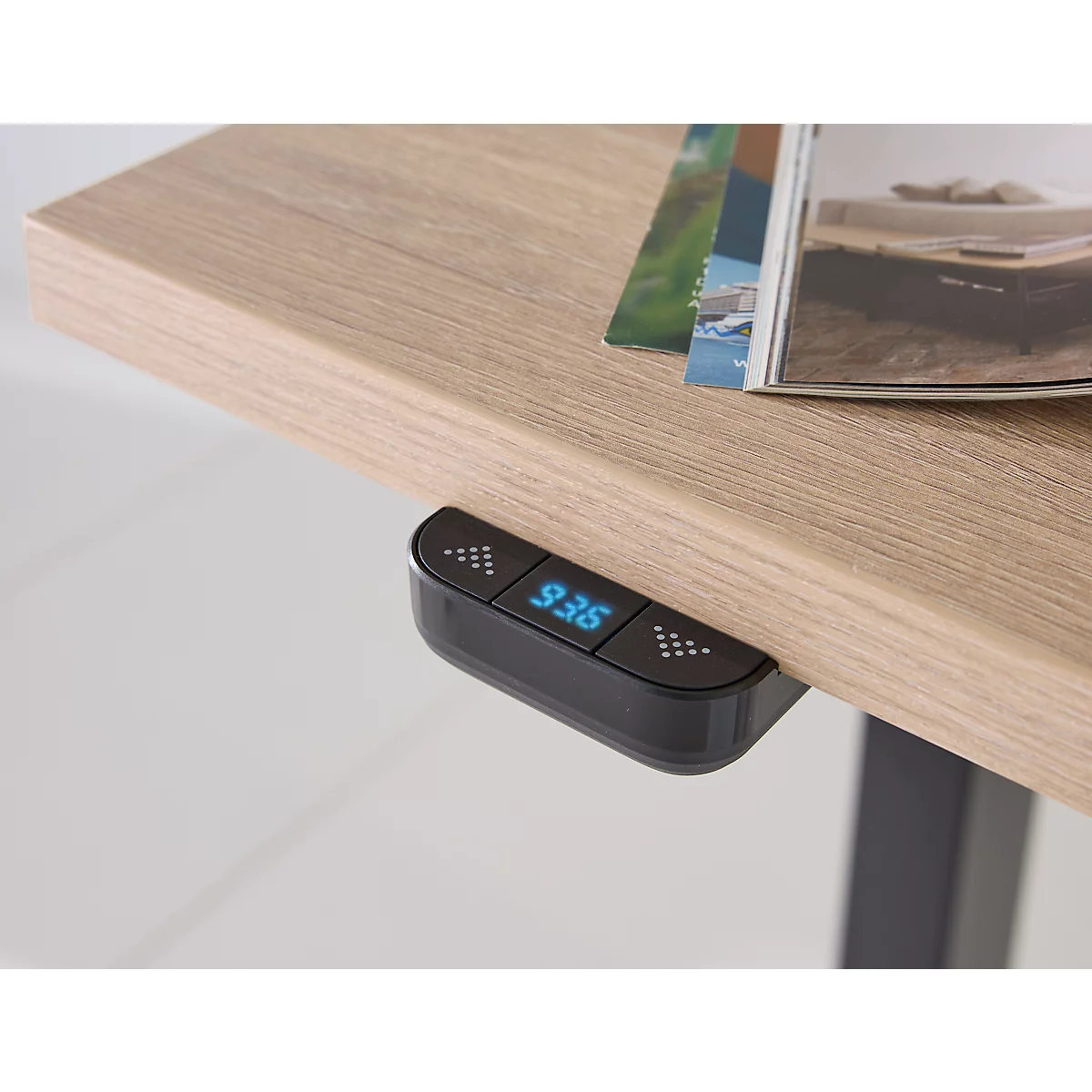 Close-up van een in hoogte verstelbaar bureau met een zwart bedieningspaneel met de tekst "93.6".